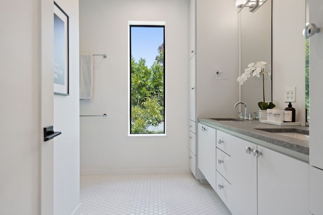 bathroom with dual vanity, tile patterned floors, and a wealth of natural light