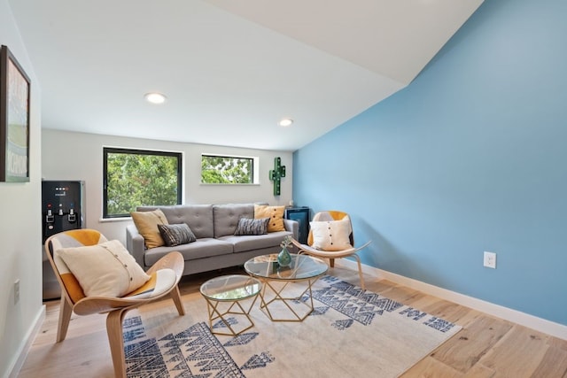 living room with light wood-type flooring and vaulted ceiling