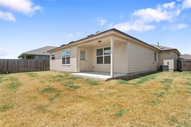 rear view of house featuring a patio, cooling unit, and a lawn