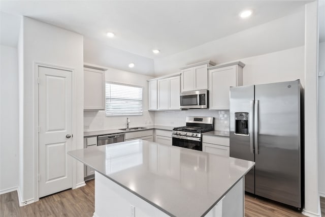 kitchen featuring sink, white cabinets, stainless steel appliances, and a kitchen island