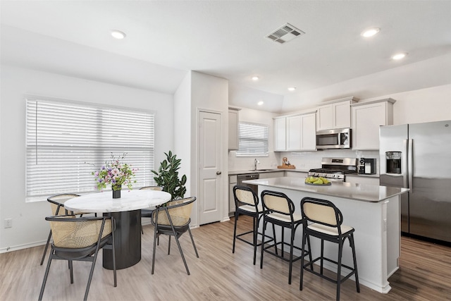 kitchen featuring plenty of natural light, a center island, white cabinetry, and appliances with stainless steel finishes