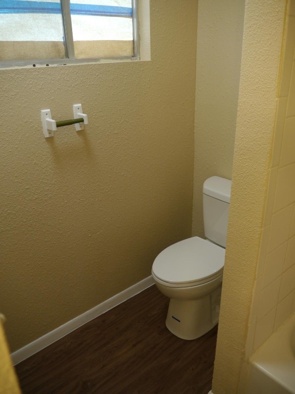 bathroom with toilet and wood-type flooring