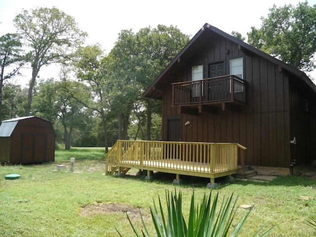 view of yard with a balcony, a shed, and a deck