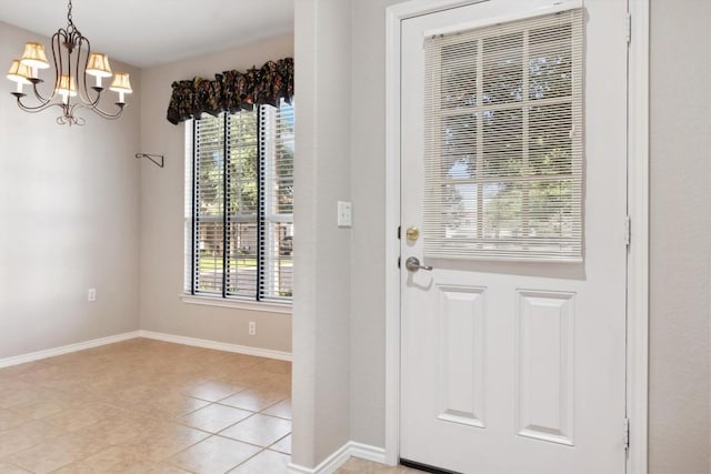 tiled foyer with a chandelier