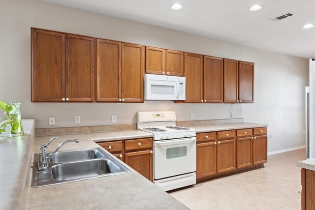 kitchen featuring sink, white appliances, and light tile patterned floors