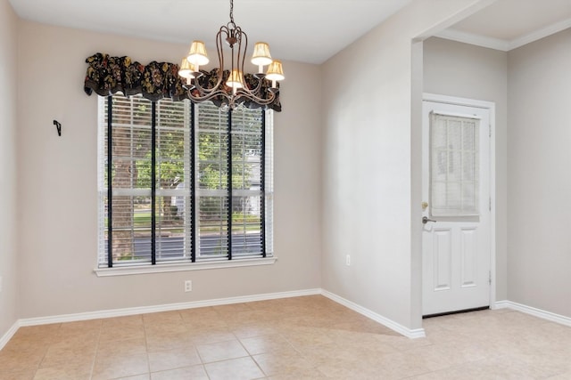 tiled spare room featuring crown molding and an inviting chandelier