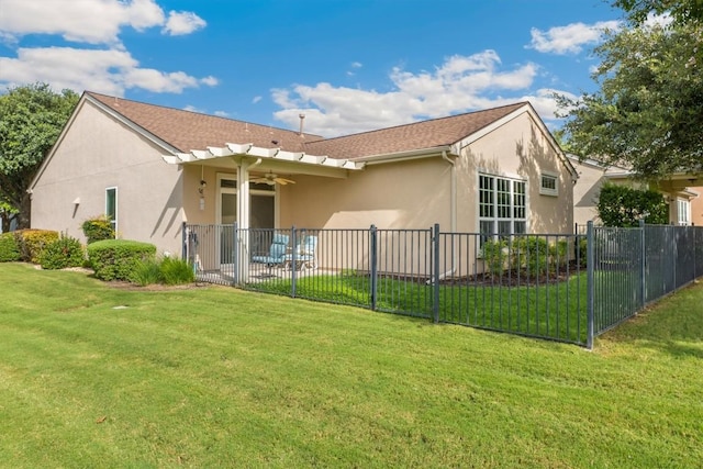 back of property featuring a yard and ceiling fan