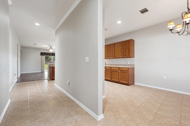 hall featuring light tile patterned floors, an inviting chandelier, and crown molding