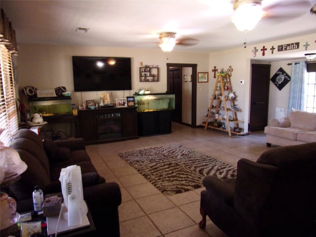 tiled living room with a fireplace and ceiling fan