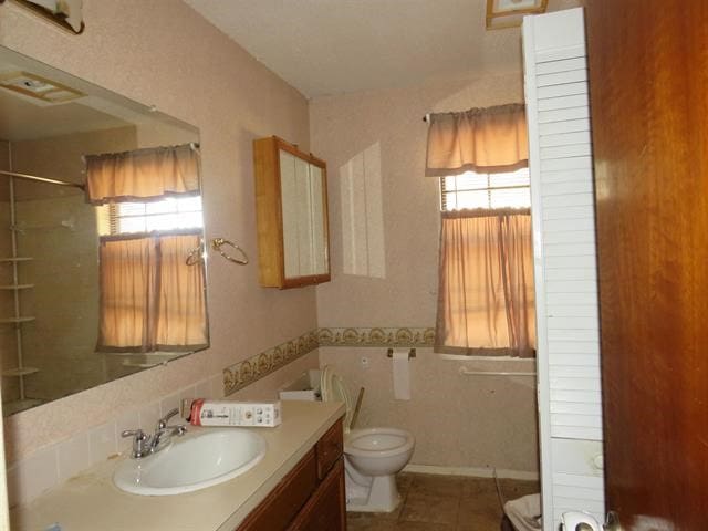 bathroom featuring toilet, tile patterned floors, and vanity