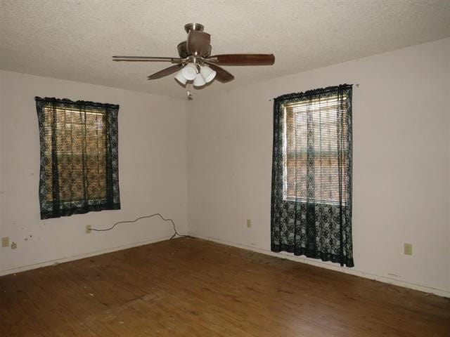 empty room with ceiling fan, a textured ceiling, and hardwood / wood-style floors