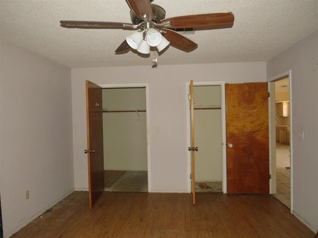105 E Fawn Dr, Buchanan Dam, TX 78609 - unfurnished bedroom featuring ceiling fan, a textured ceiling, two closets, and wood finished floors
