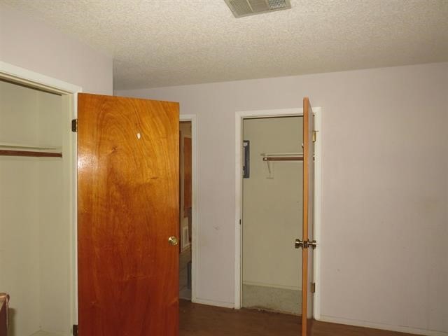 unfurnished bedroom with a textured ceiling, carpet flooring, and a closet