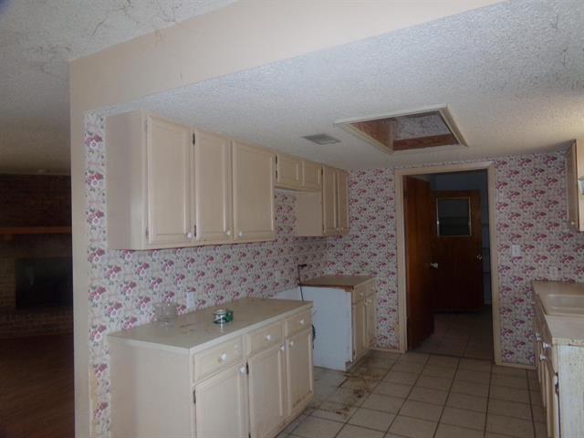 kitchen featuring light tile patterned floors, sink, a textured ceiling, and cream cabinets