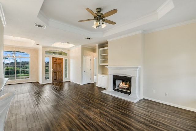 unfurnished living room featuring crown molding, dark wood-type flooring, ceiling fan, and a raised ceiling