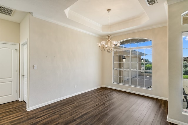 unfurnished dining area with crown molding, dark hardwood / wood-style flooring, a tray ceiling, and a chandelier