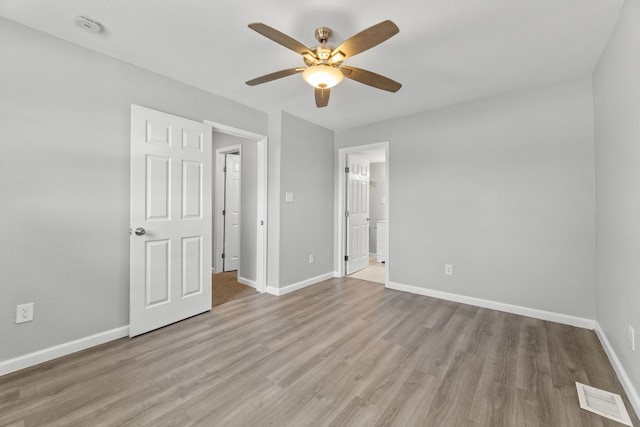 unfurnished bedroom featuring light wood-style floors, baseboards, and visible vents