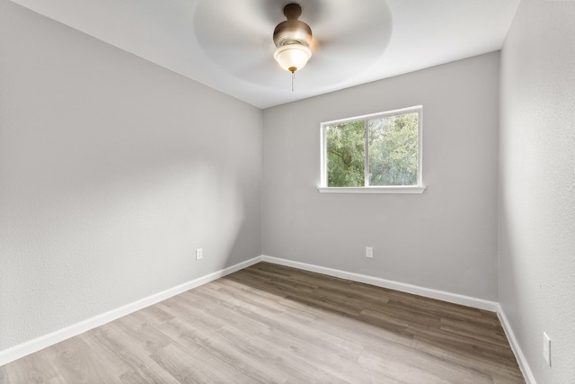 unfurnished room featuring ceiling fan, light wood finished floors, and baseboards