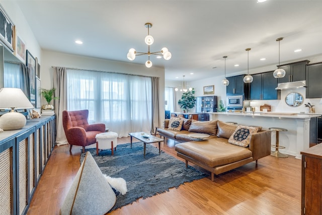 living room featuring an inviting chandelier and light hardwood / wood-style floors