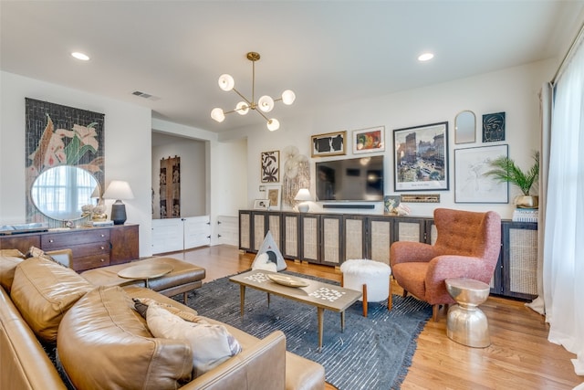 living room featuring a notable chandelier and light hardwood / wood-style floors