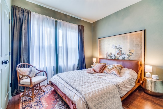 bedroom with hardwood / wood-style flooring and multiple windows