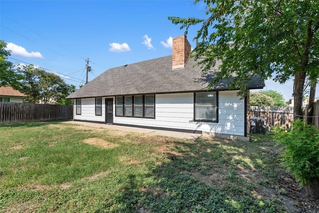 rear view of property featuring a lawn