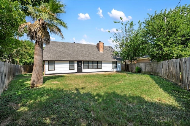 rear view of property with a yard