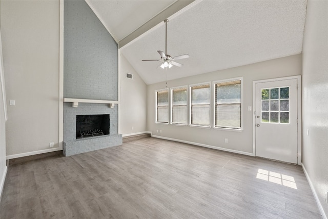 unfurnished living room featuring a textured ceiling, a fireplace, ceiling fan, and light hardwood / wood-style floors