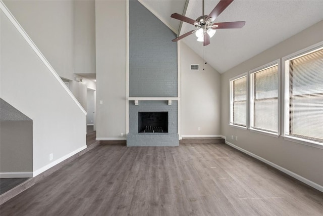 unfurnished living room featuring a fireplace, hardwood / wood-style flooring, high vaulted ceiling, and ceiling fan