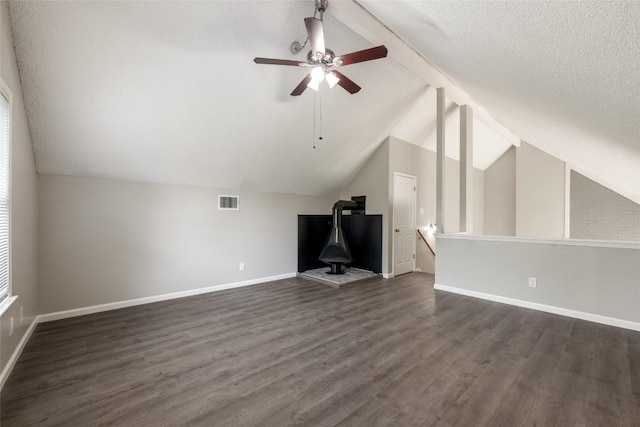 bonus room with ceiling fan, a textured ceiling, vaulted ceiling with beams, and dark hardwood / wood-style floors