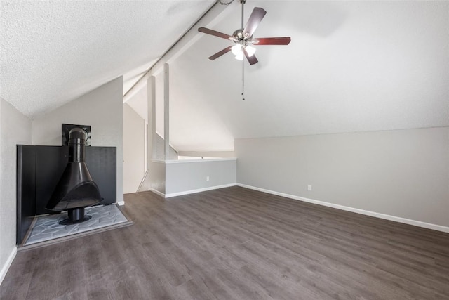 additional living space featuring ceiling fan, vaulted ceiling with beams, dark hardwood / wood-style flooring, and a textured ceiling