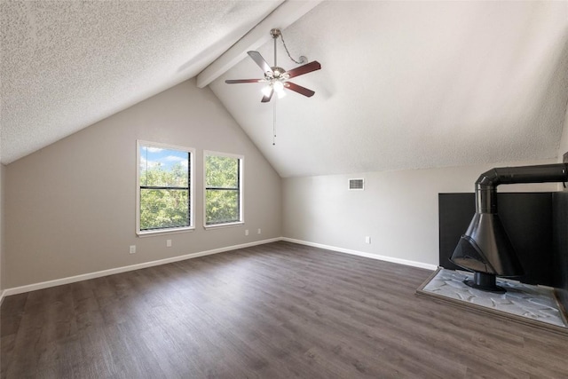 additional living space with ceiling fan, a textured ceiling, vaulted ceiling with beams, and dark hardwood / wood-style floors