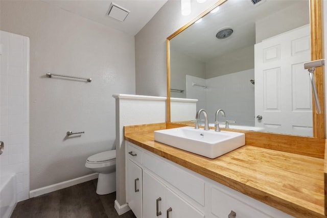 full bathroom with hardwood / wood-style floors, bathtub / shower combination, vanity, and toilet