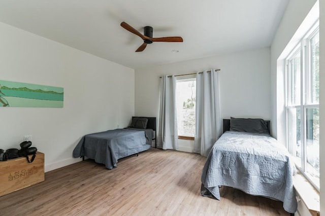 107 Blue Ridge Trl, Austin, TX 78746 - bedroom with multiple windows, light wood-style floors, a ceiling fan, and baseboards
