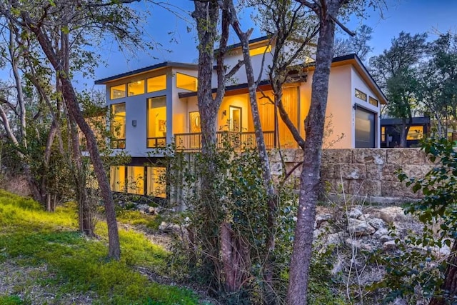 107 Blue Ridge Trl, Austin, TX 78746 - back of property featuring stucco siding, a garage, a balcony, and stone siding
