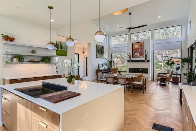 107 Blue Ridge Trl, Austin, TX 78746 - kitchen with a towering ceiling, a ceiling fan, decorative light fixtures, light countertops, and modern cabinets