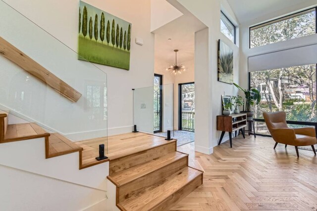 107 Blue Ridge Trl, Austin, TX 78746 - stairs with a high ceiling, baseboards, and a chandelier