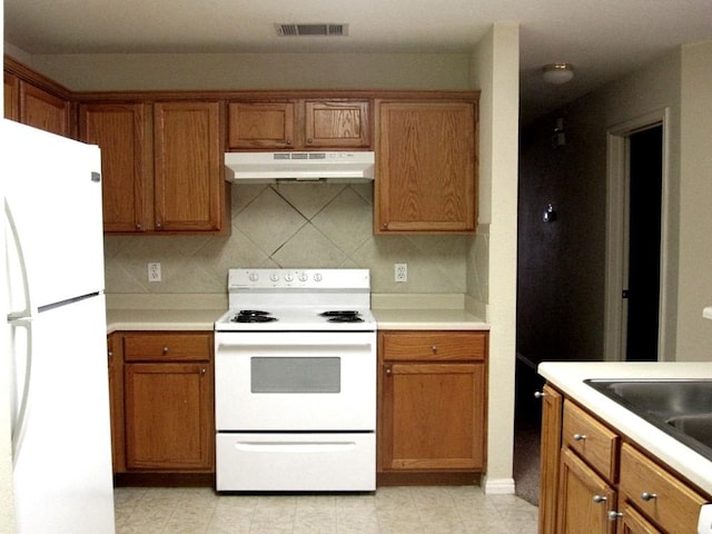 kitchen featuring sink, backsplash, and white appliances