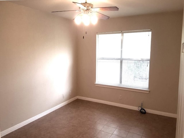 tiled spare room with ceiling fan