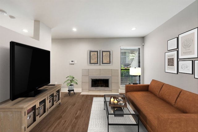 living room with dark wood-type flooring and a tiled fireplace