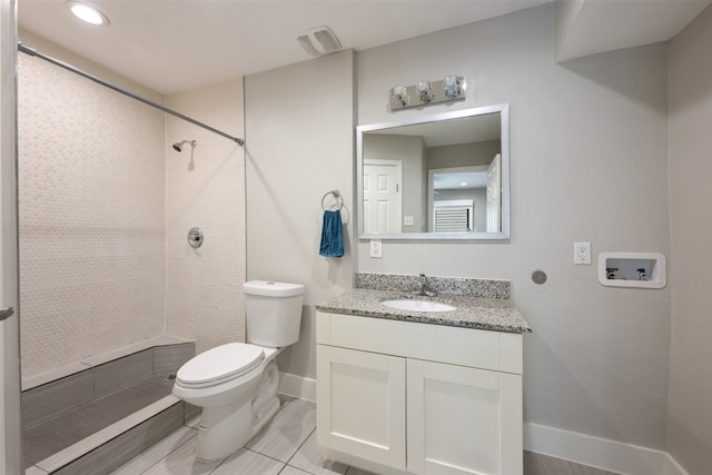 bathroom with tile patterned floors, a tile shower, vanity, and toilet