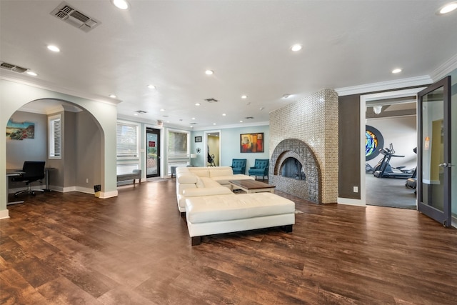 living room with crown molding, dark hardwood / wood-style flooring, and a fireplace