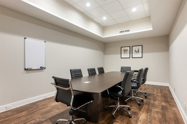 office with a paneled ceiling, dark hardwood / wood-style flooring, and a raised ceiling