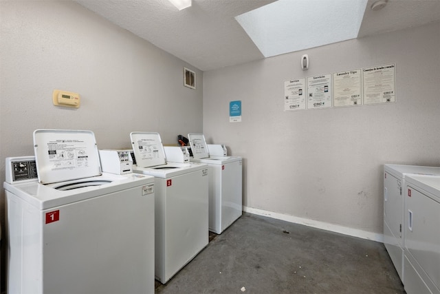 laundry room featuring washer and dryer and a textured ceiling