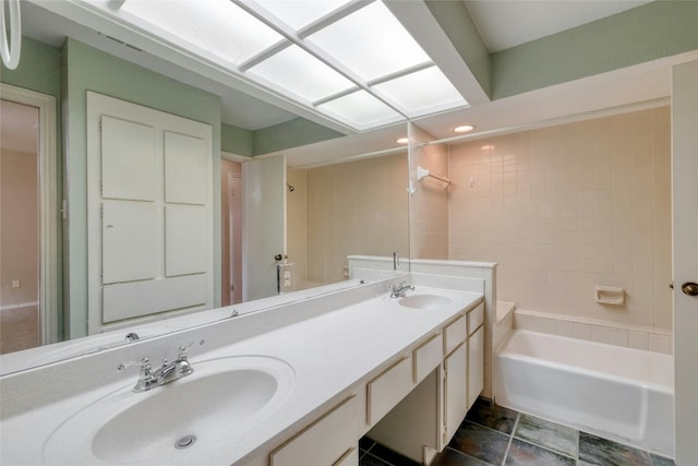 bathroom featuring tile patterned flooring, vanity, and tiled shower / bath