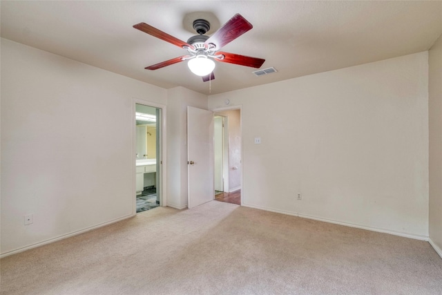 unfurnished bedroom featuring ceiling fan, light colored carpet, and connected bathroom