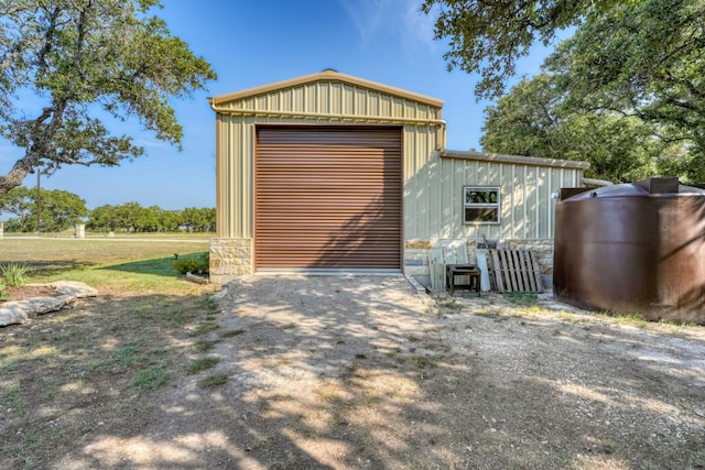 detached garage featuring dirt driveway