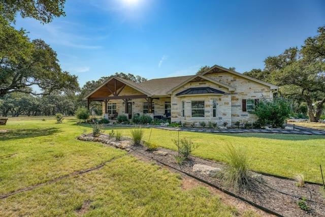 craftsman-style house with stone siding and a front yard