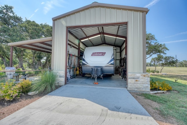 view of vehicle parking with concrete driveway and a detached garage