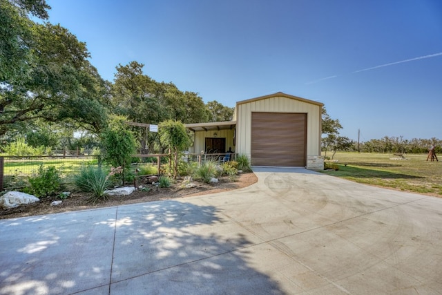 view of front facade featuring driveway and fence